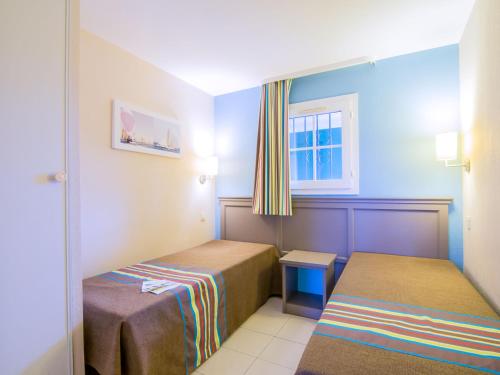 une petite chambre avec deux lits et une fenêtre dans l'établissement Apartment Les Marines-8 by Interhome, à La Foux