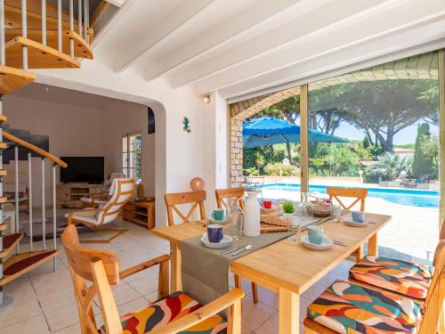 ein Esszimmer mit einem Tisch, Stühlen und einem Pool in der Unterkunft Villa Ohana by Interhome in Sainte-Maxime