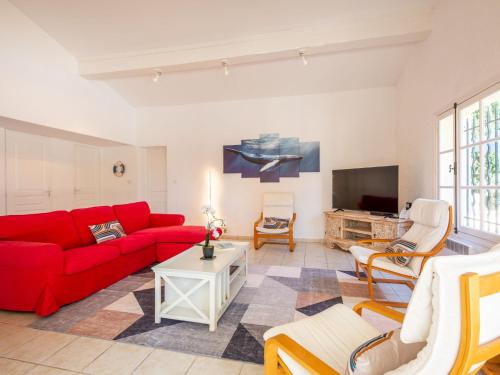 un salon avec un canapé rouge et une télévision dans l'établissement Villa Ohana by Interhome, à Sainte-Maxime