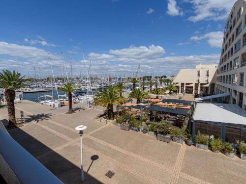 un port de plaisance avec des bateaux et des palmiers ainsi qu'un bâtiment dans l'établissement Apartment Le Suffren-2 by Interhome, au Grau-du-Roi