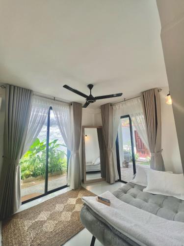 a bedroom with a couch and a ceiling fan at Villa Vikasa Colombo in Colombo