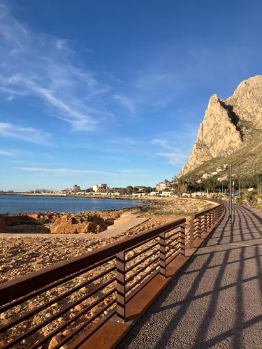 Un paseo marítimo en la playa con montañas al fondo en Itaca, en Palermo