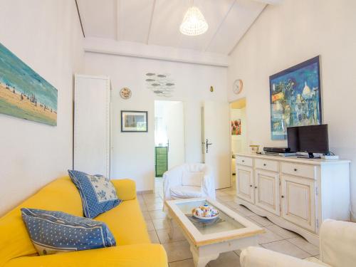 - un salon avec un canapé jaune et une télévision dans l'établissement Holiday Home Les Parcs de Gassin-2 by Interhome, à Saint-Tropez