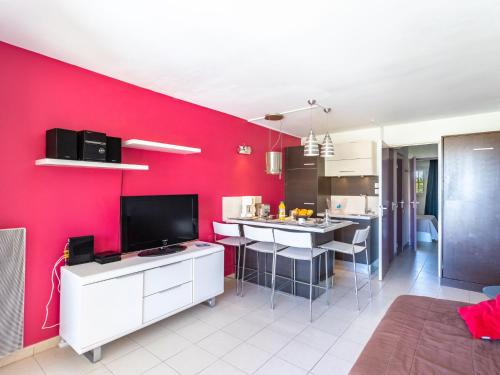 ein Wohnzimmer mit einer Wand mit roten Akzenten in der Unterkunft Apartment Les Marines-1 by Interhome in La Foux