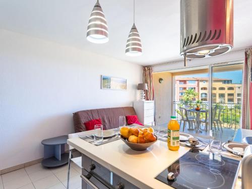 une cuisine avec une table avec un bol de fruits dessus dans l'établissement Apartment Les Marines-1 by Interhome, à La Foux