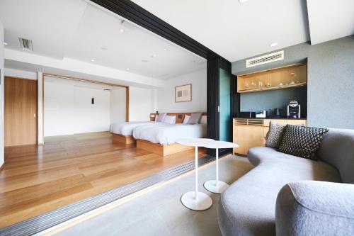 a hotel room with two beds and a couch at Arima Onsen Takayamaso Hanano in Kobe