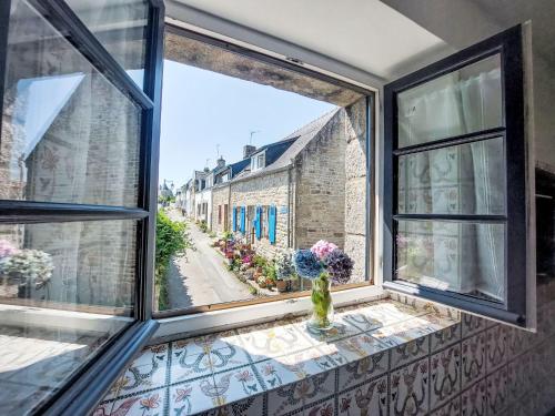 une fenêtre ouverte avec un vase de fleurs sur un rebord de fenêtre dans l'établissement Apartment Er Velin by Interhome, à La Trinité-sur-Mer