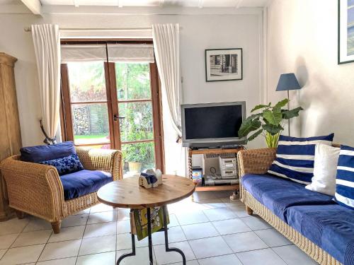 a living room with two couches and a tv at Holiday Home Noordzeepark Zeewind 2-12 by Interhome in Bredene