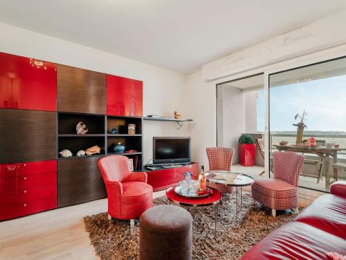 Il comprend un salon doté d'un mobilier rouge et d'une télévision. dans l'établissement Apartment Terrasses d'Emeraude-7 by Interhome, à Dinard