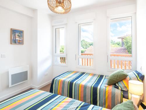 a bedroom with two beds and two windows at Apartment Jade et Elena-3 by Interhome in Lit-et-Mixe