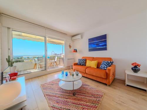 un salon avec un canapé orange et une table dans l'établissement Studio Les Terrasses de la Mer-18 by Interhome, à La Grande Motte