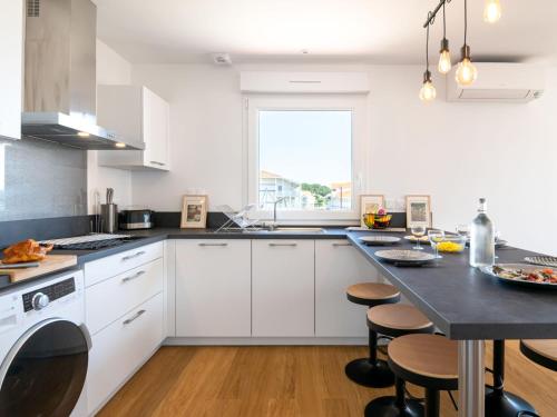 une cuisine avec des armoires blanches et un comptoir noir dans l'établissement Apartment La Pergola by Interhome, à Mimizan