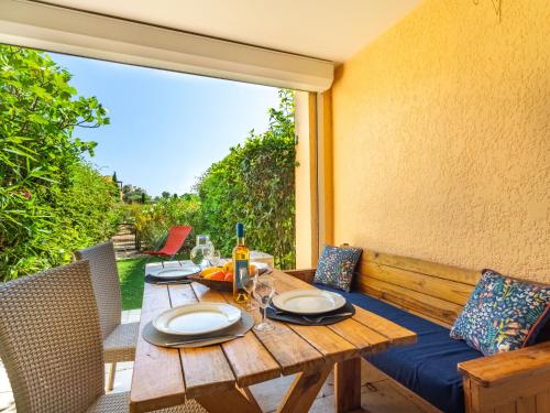 une table en bois avec des assiettes de nourriture sur une terrasse dans l'établissement Apartment Les Marines-9 by Interhome, à La Foux