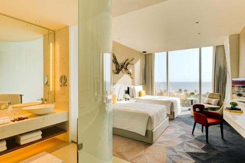 a hotel room with two beds and a bathroom at Cinnamon Life at City of Dreams in Colombo