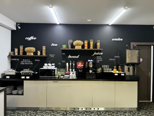a coffee shop with a black wall and a counter at Thomas Albert Hotel in Chişinău