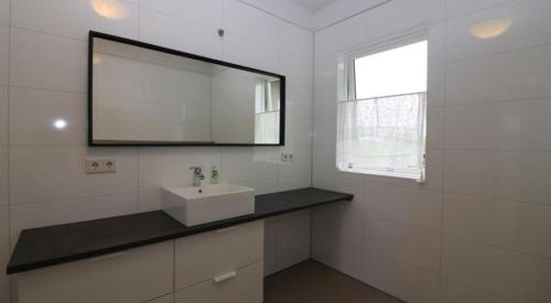 a white bathroom with a sink and a mirror at Golden Circle Spectacular house! in Ásborgir