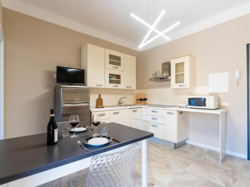 a kitchen with white cabinets and a black counter top at Apartment Nives by Interhome in Diano Marina