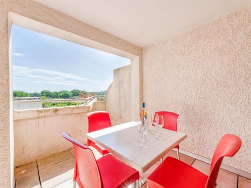 une salle à manger avec des chaises rouges, une table et une fenêtre dans l'établissement Apartment Les Marines-12 by Interhome, à Gassin