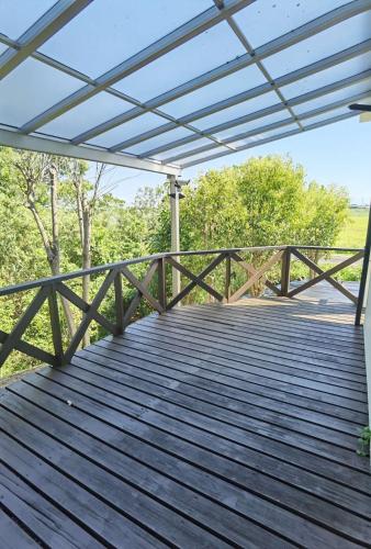 a wooden boardwalk with awning over a deck at リニューアル 高島市風車村琵琶湖畔別荘サウナ付きファミリーグループ大歓迎テラス炭火BBQ Reiwa House in Takashima