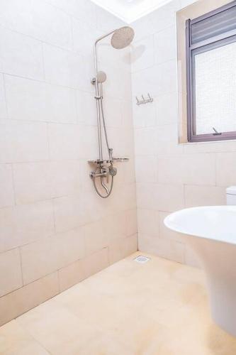 a white bathroom with a shower and a sink at The beautiful Shams AO9 in Entebbe