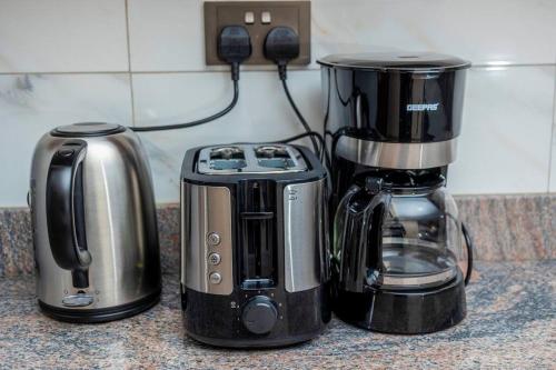 a kitchen counter with a coffee maker and a toaster at The beautiful Shams AO9 in Entebbe