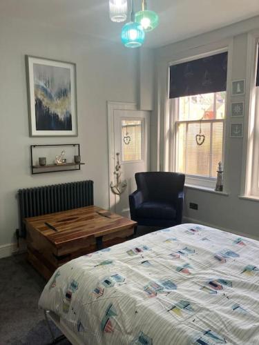a bedroom with a bed and a desk and a chair at Crown Cove in Pakefield