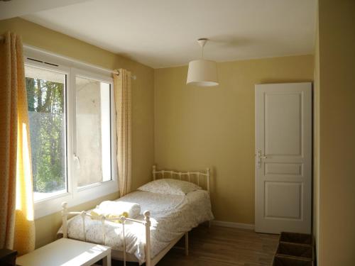 a small bedroom with a bed and a window at Mirathe in Baleyssagues