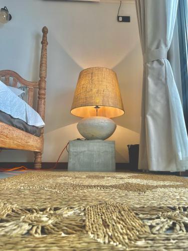 a lamp sitting on a table next to a bed at Villa Vikasa Colombo in Colombo