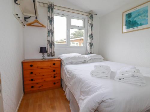 a bedroom with a white bed and a window at Constantine Bay in Padstow