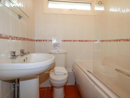 a bathroom with a sink and a toilet and a tub at Constantine Bay in Padstow