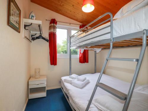 a bunk bed in a room with a ladder at Newtrain Bay in Padstow