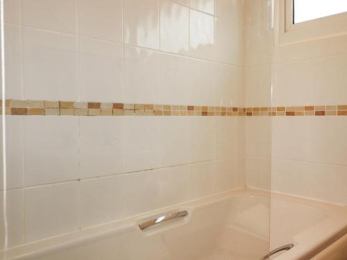 a bathroom with a tub and a window at Newtrain Bay in Padstow