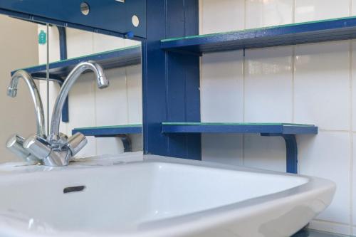 a white sink in a bathroom with a blue shelf at Maison mitoyenne cœur de ville à deux pas du port de pêche et de la plage Les Sables - 6 personnes in Les Sables-dʼOlonne