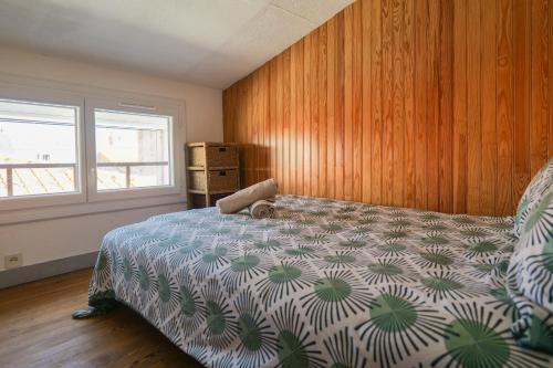 a bedroom with a bed and wooden walls and a window at Maison mitoyenne cœur de ville à deux pas du port de pêche et de la plage Les Sables - 6 personnes in Les Sables-dʼOlonne