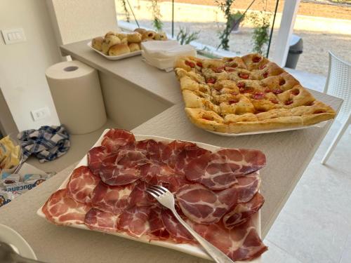 a table with two plates of meat and pies at Luna D'Argento in Leporano Marina