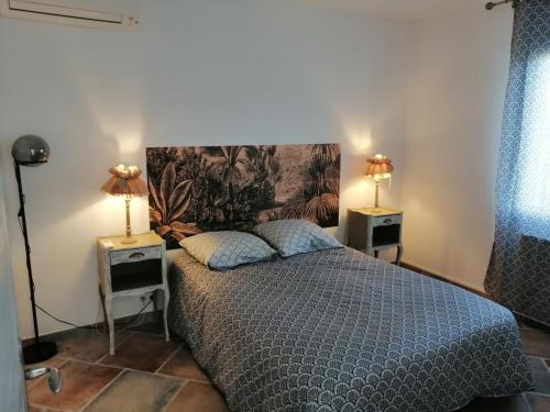 - une chambre avec un lit et deux lampes sur deux tables dans l'établissement Gîte des oliviers, à Saint-Christol-de-Rodières