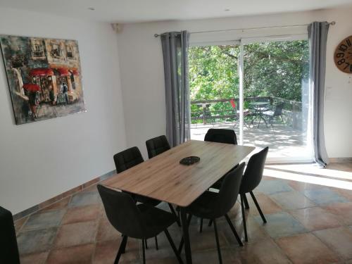 une salle à manger avec une table et des chaises en bois dans l'établissement Gîte des oliviers, à Saint-Christol-de-Rodières