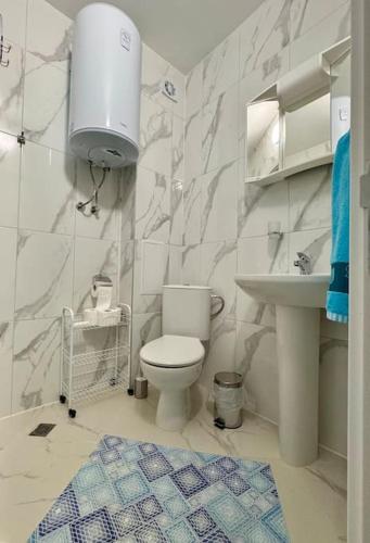 a bathroom with a toilet and a sink at Sunset studio in Shartrez in Shkorpilovtsi