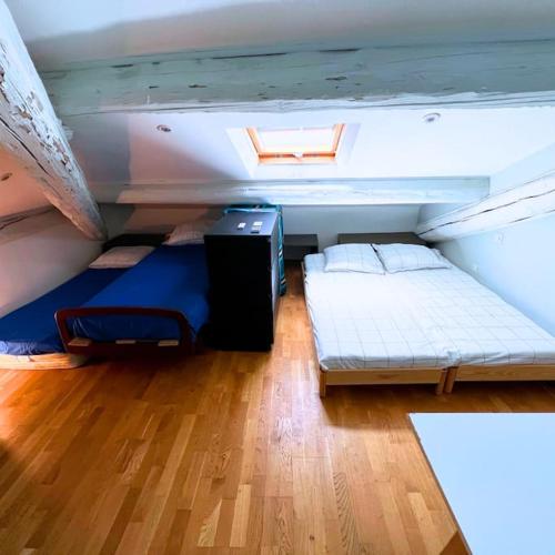Cette chambre mansardée comprend 2 lits et une fenêtre. dans l'établissement T4 Familial-Clim-St Charles, à Marseille