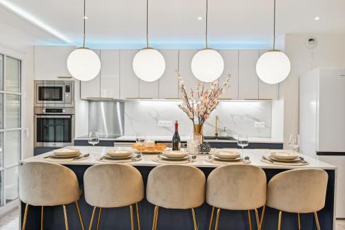 une cuisine avec une table, des chaises et des lumières dans l'établissement Premium and spacious apart with terrace and parking, à Courbevoie