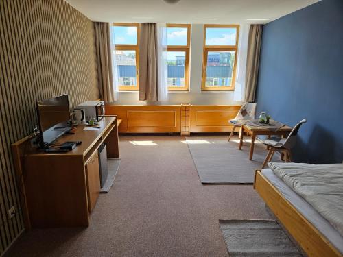 a room with a bed and a desk with a computer at Hotel Garni in Rodewisch