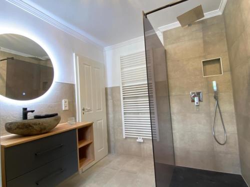 a bathroom with a shower with a sink and a mirror at Cottage Sleeps 6 with Parking in Lupburg
