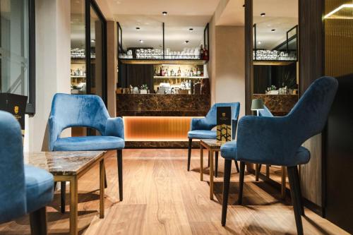 a waiting room with blue chairs and a bar at Aktivhotel Santalucia in Nago-Torbole