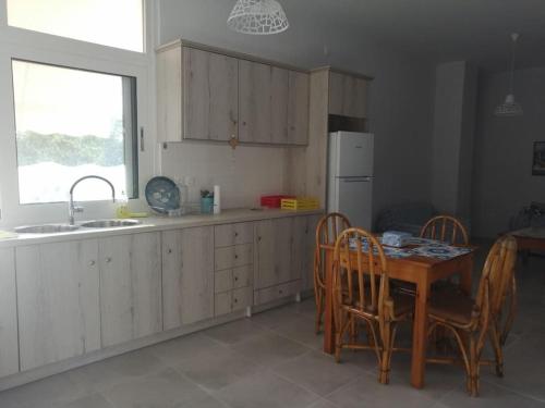 a kitchen with a table and chairs and a sink at Natalia's Serene Hub in Aegina Town