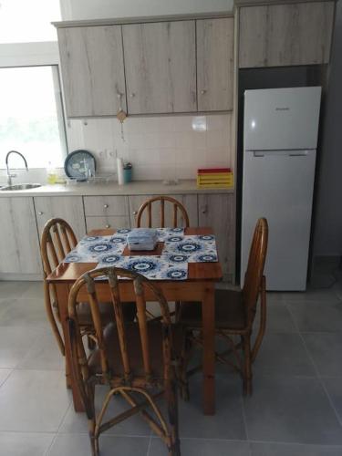 a kitchen with a table and chairs and a refrigerator at Natalia's Serene Hub in Aegina Town