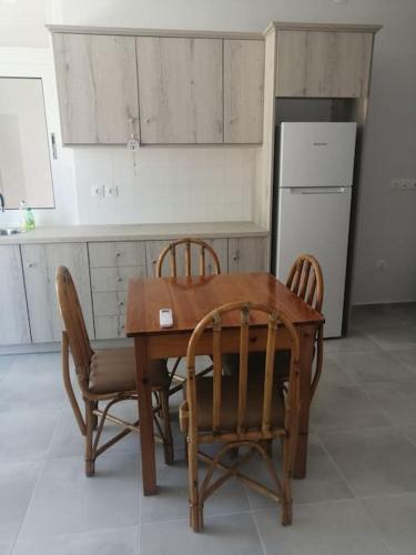 a kitchen with a table and chairs and a refrigerator at Natalia's Serene Hub in Aegina Town