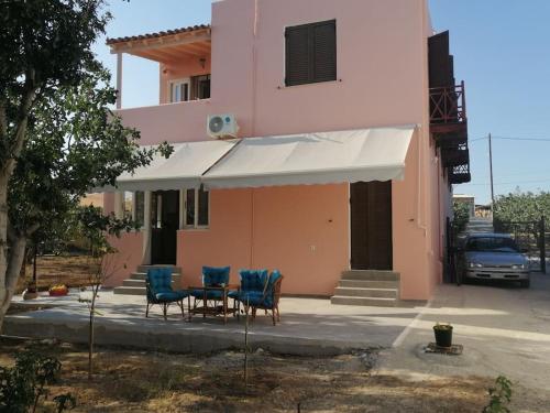 a house with a table and chairs in front of it at Natalia's Serene Hub in Aegina Town