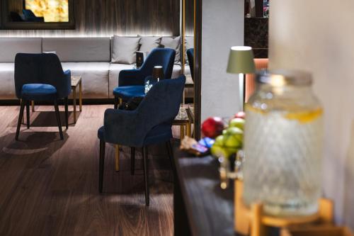 a waiting room with blue chairs and a table with a lamp at Aktivhotel Santalucia in Nago-Torbole
