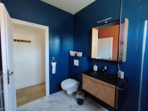 a blue bathroom with a toilet and a sink at Au Pti' Bonheur in Saint-Coulomb