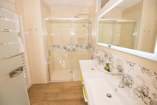 La salle de bains est pourvue d'une douche et d'un lavabo blanc. dans l'établissement Lorenzerhof, à Sankt Lorenzen am Wechsel